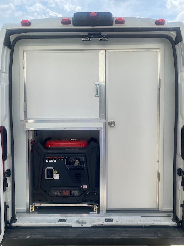 The back of a white van with a generator in the back.