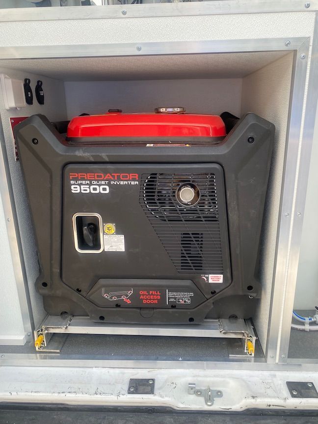 A honda generator is sitting in the back of a van.