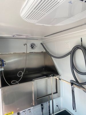 A stainless steel sink with a vacuum hose attached to it.