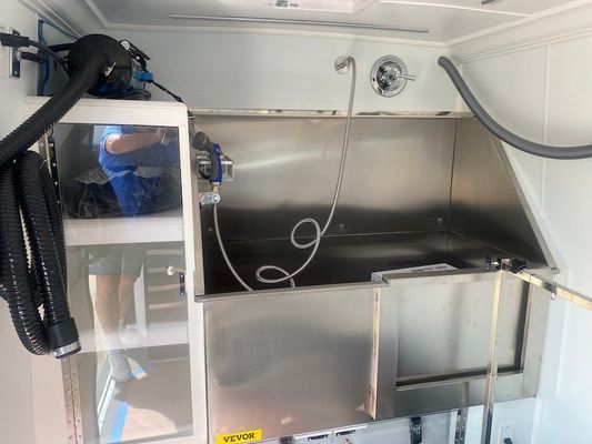 A stainless steel sink with a vacuum hose attached to it