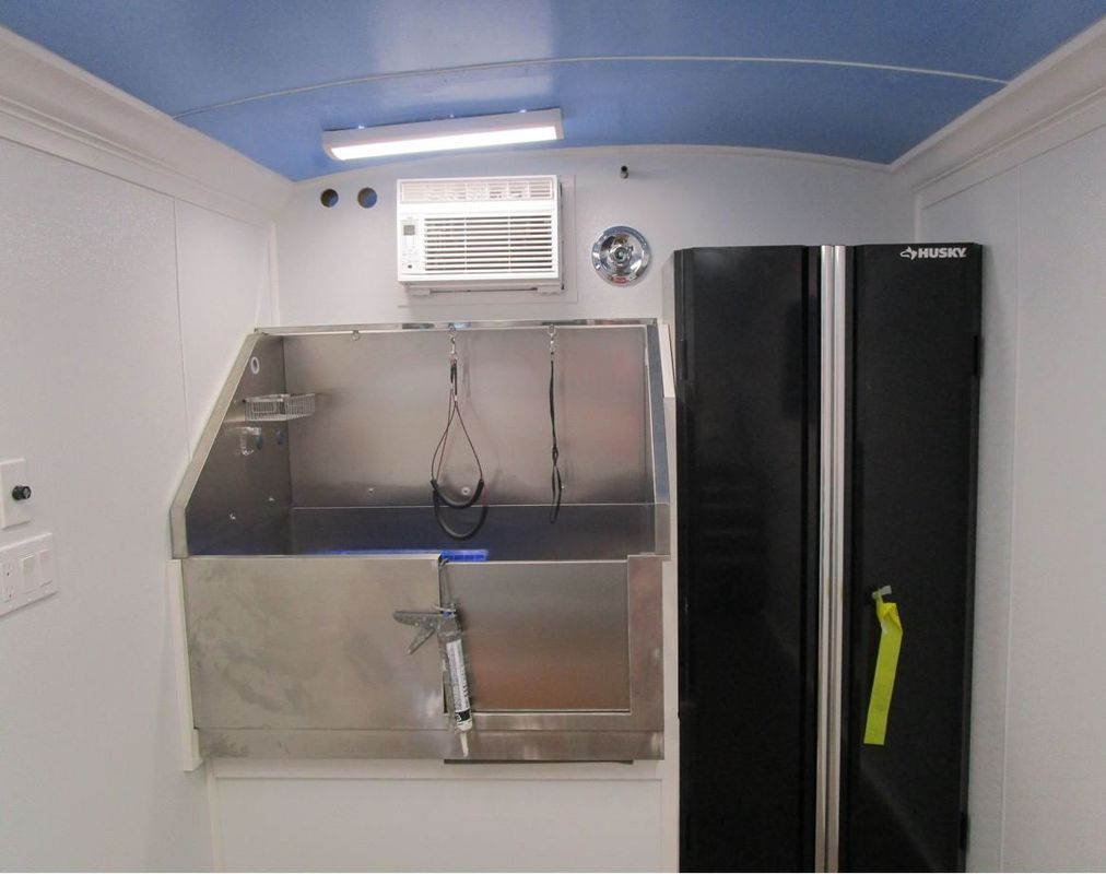 A black husky refrigerator sits next to a stainless steel sink
