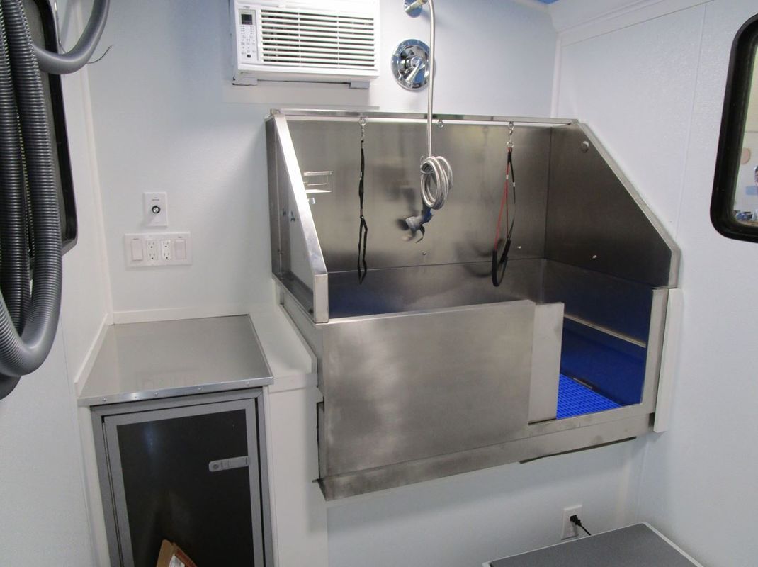 A bathroom with a stainless steel sink and a mirror