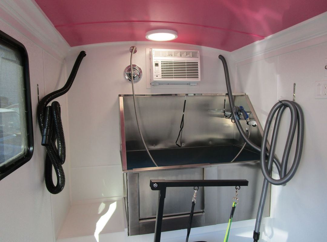 A stainless steel bathtub with a pink ceiling