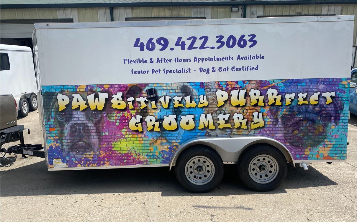 A trailer that says pawsitively purrfect groomers on it
