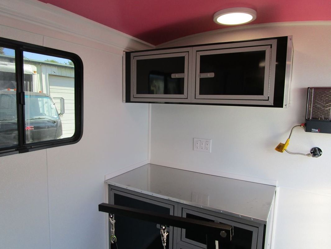 A white room with a pink ceiling and a desk.