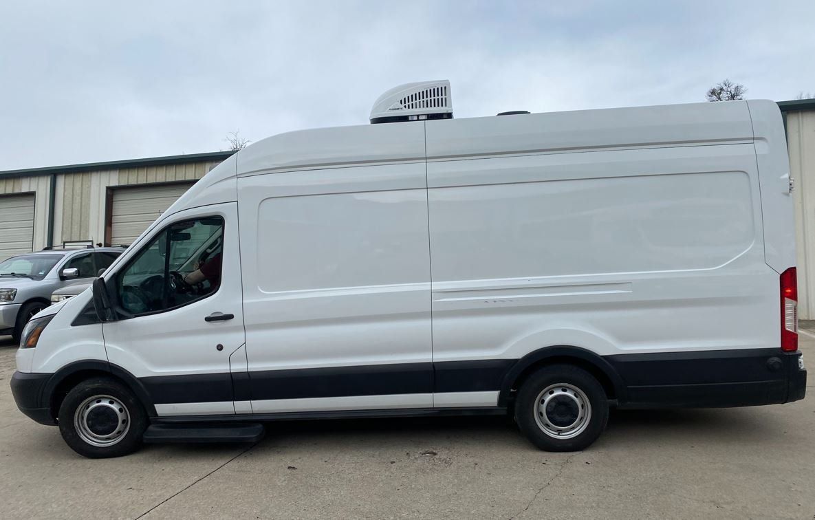 A white van is parked in front of a building.