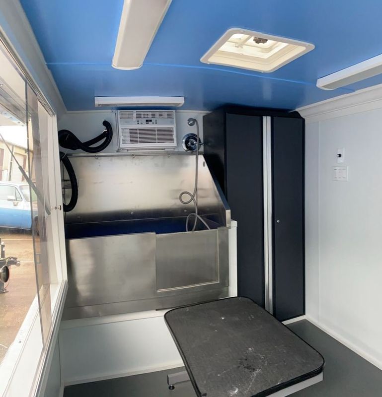 A room with a stainless steel tub and a table