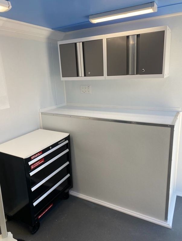 A room with a dresser and cabinets and a blue ceiling