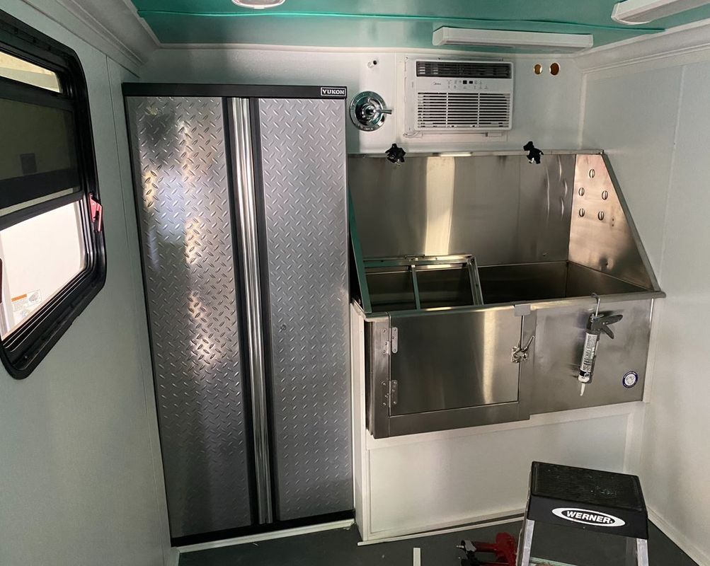 A kitchen with a refrigerator , sink , and window.