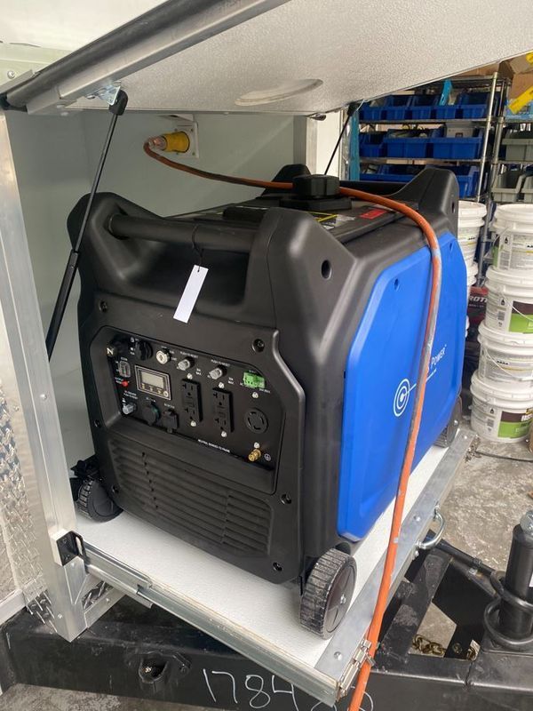 A blue and black generator is sitting on top of a trailer.