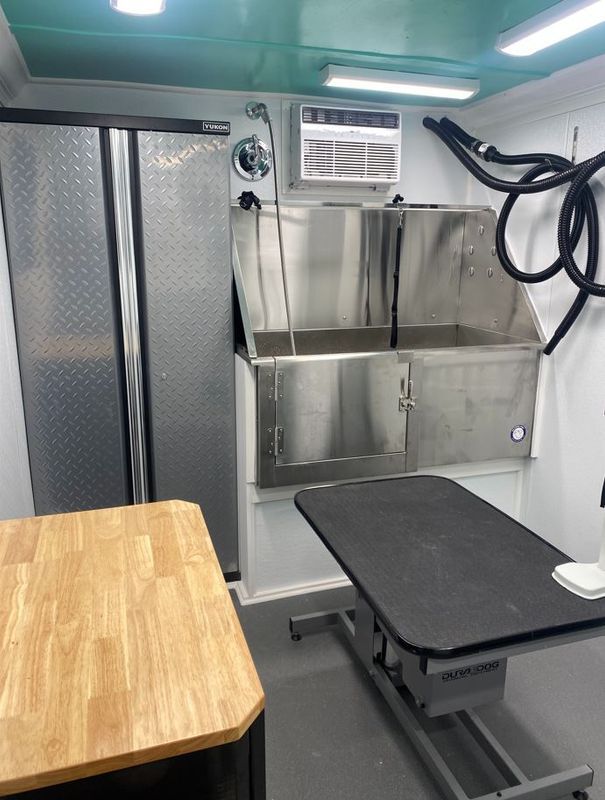 A room with a stainless steel sink and a wooden table