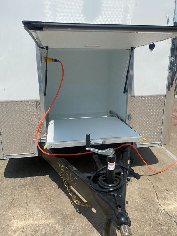 A trailer with the door open and a hose attached to it