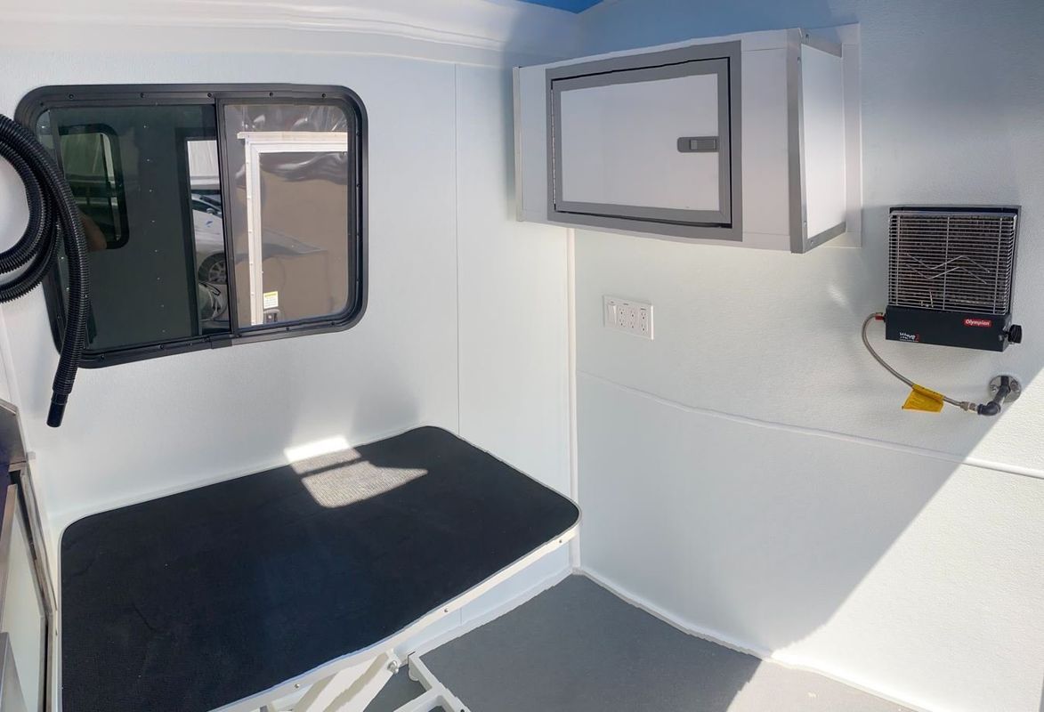 The inside of an ambulance with a bed and a window.