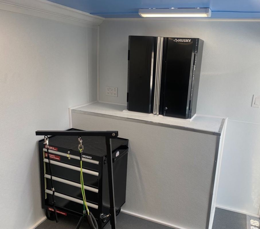 A room with two refrigerators and a toolbox on the floor.