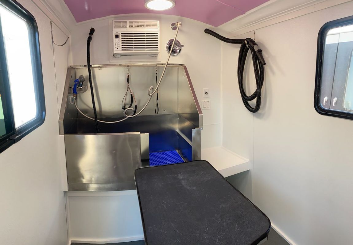 A dog grooming van with a stainless steel bathtub