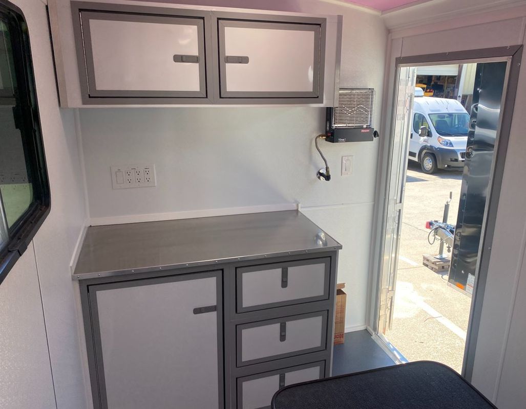 The inside of a trailer with a table and cabinets
