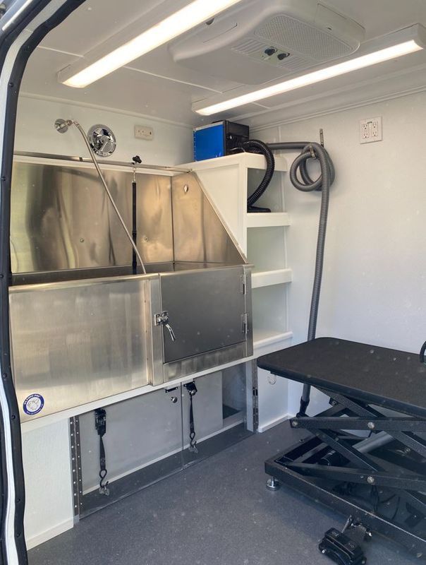 A van with a stainless steel sink and a grooming table