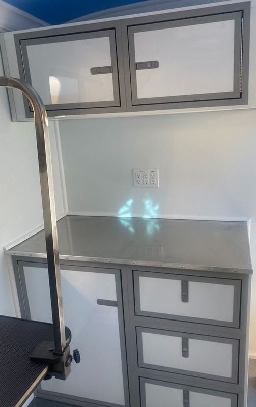 There is a stainless steel counter top in the middle of the room.