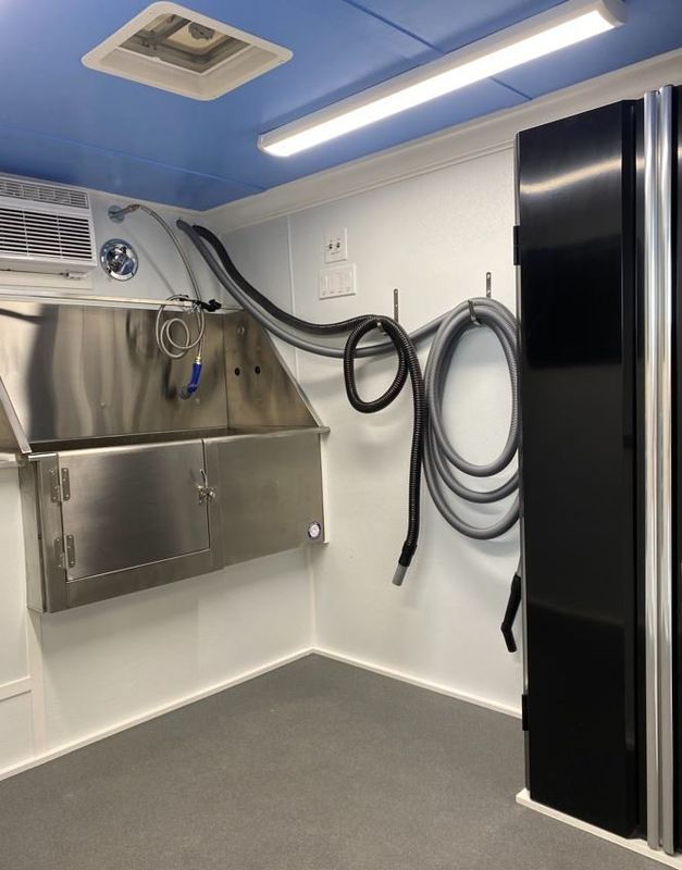 A room with a stainless steel sink and a black door