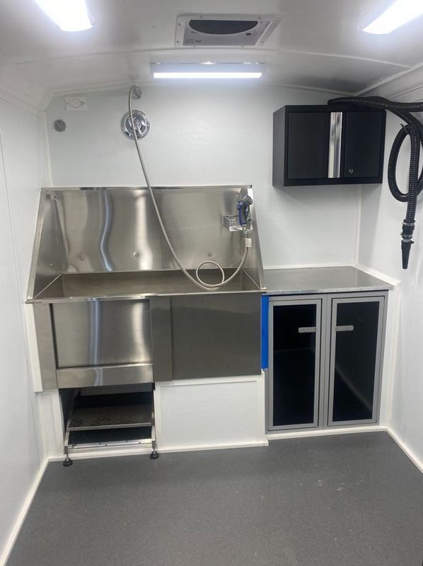A room with a stainless steel sink and cabinets