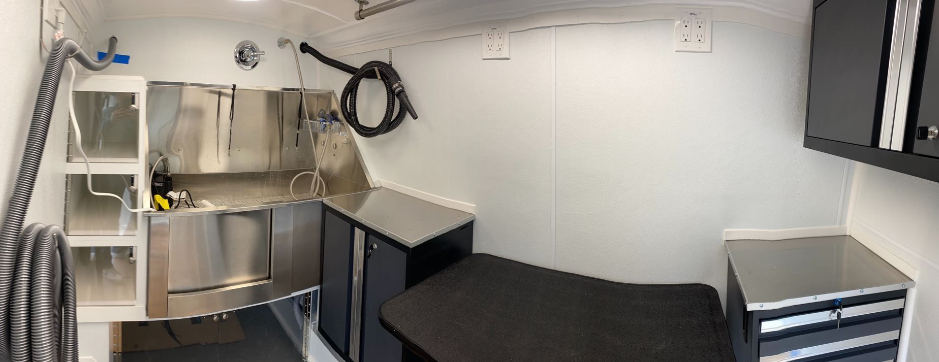 A kitchen with a sink , cabinets , drawers and a table.