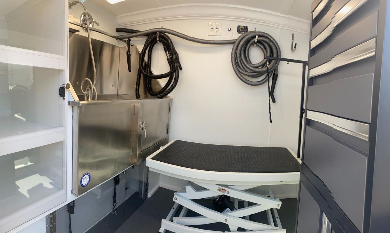 A dog grooming van with a sink and a table