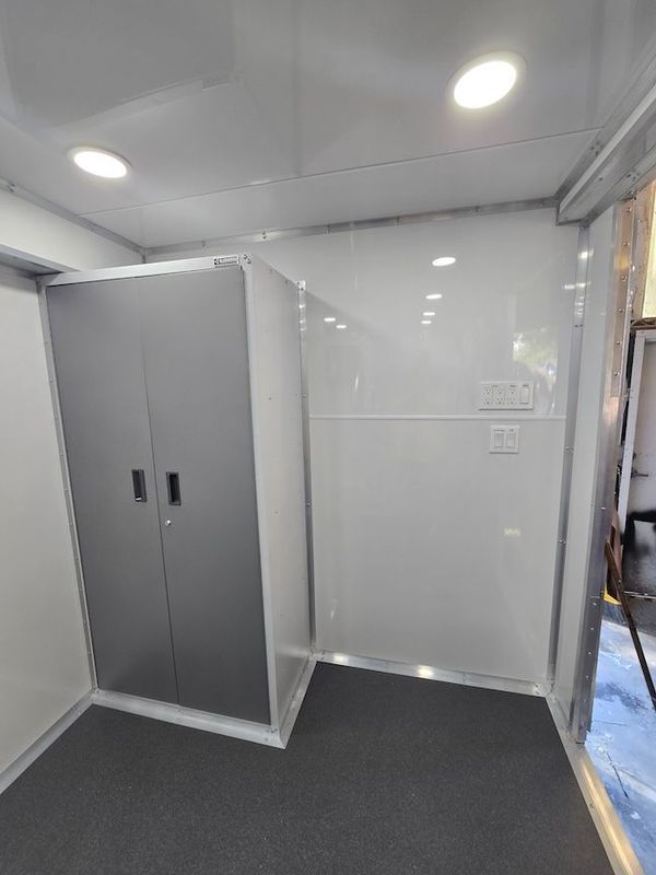 A room with a gray cabinet and a white wall.