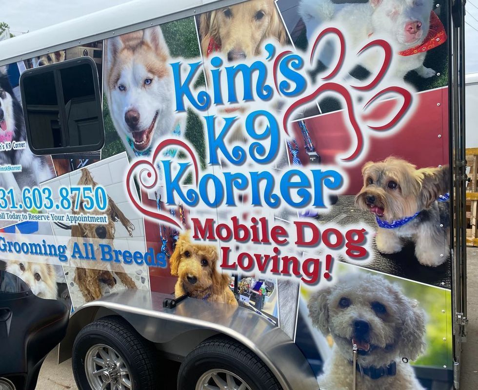 A trailer that says kim 's k9 korner mobile dog loving
