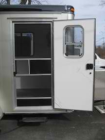 A white trailer with the door open and a window.