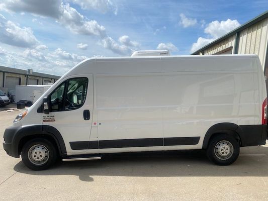 A white van is parked in front of a building.