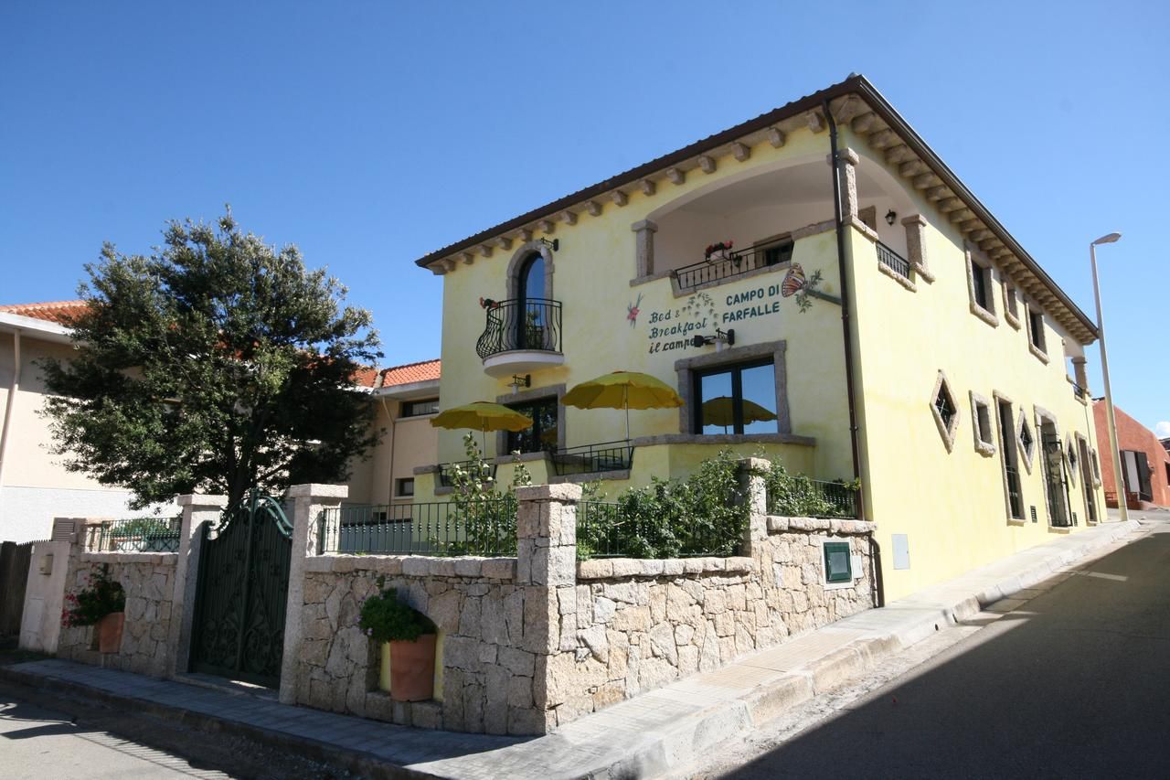 Una casa gialla con degli ombrelli davanti