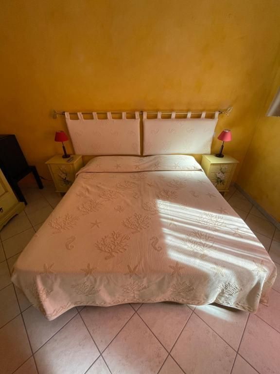 Una camera da letto con un letto, due comodini e due lampade.
