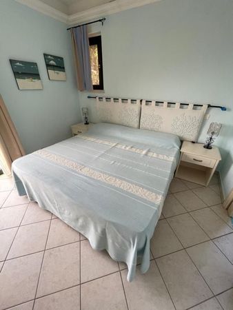 A bedroom with a large bed and two bedside tables.