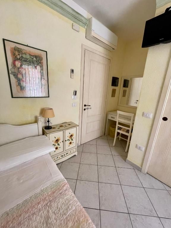 Una camera da letto con un divano, una scrivania e una televisione