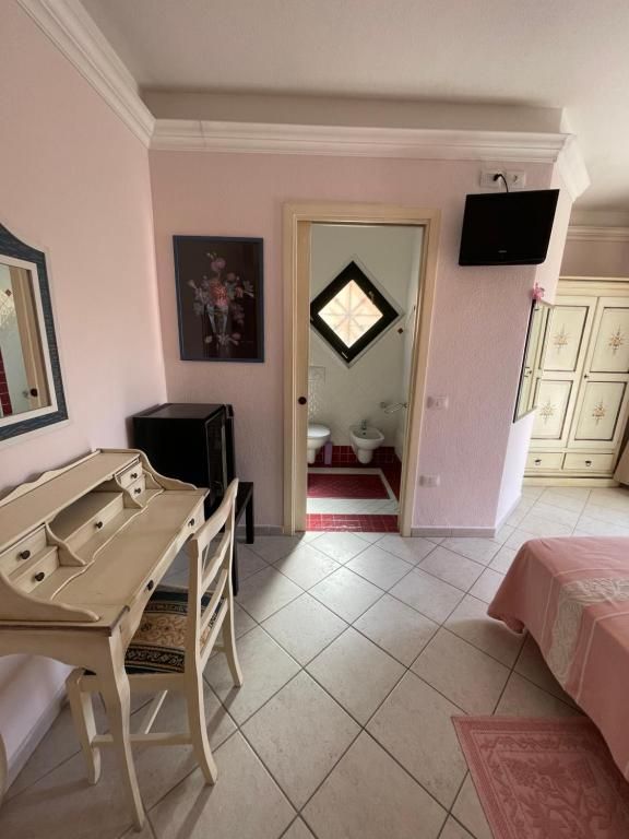 Una camera da letto con pareti rosa, scrivania e sedia