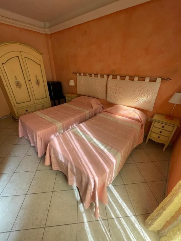 Una camera da letto con due letti, un comodino e un armadio.