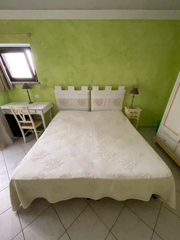 Una camera da letto con un letto, una scrivania, una sedia e delle lampade.