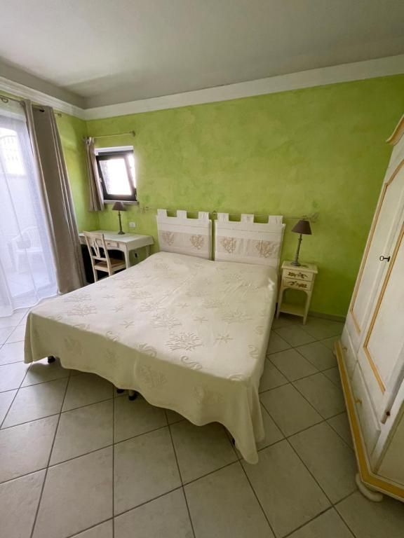 Una camera da letto con un letto, una scrivania, un comodino e un armadio.