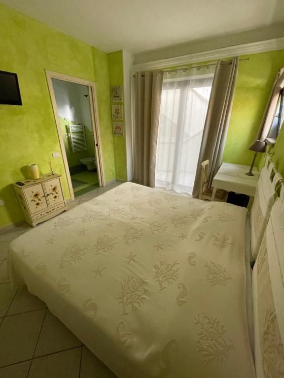 Una camera da letto con letto, comodino, televisione e porte scorrevoli in vetro.