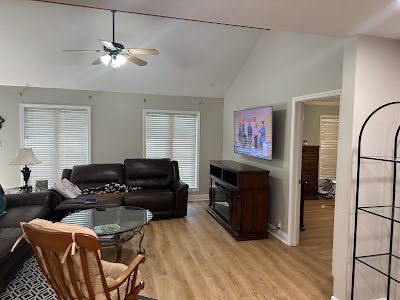 A living room with a couch , chair , table and television.