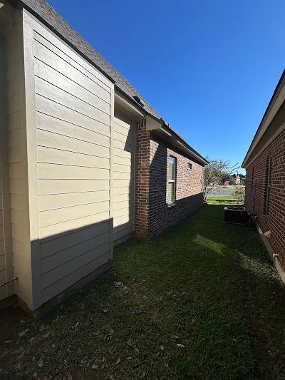 A house with a brick wall and a white siding on the side of it.