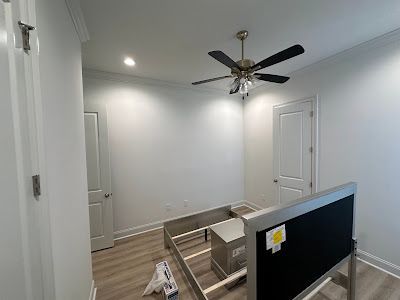 A bedroom with a bed frame and a ceiling fan.