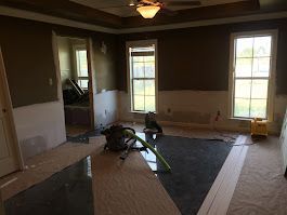 A room with a vacuum cleaner on the floor and a ceiling fan.