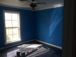 A room with blue walls and a ceiling fan.
