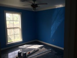 A room with blue walls and a ceiling fan.