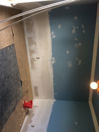 A bathroom is being painted blue and white.