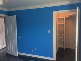 A bedroom with blue walls and a walk in closet.