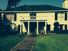 A large white house with a brick walkway leading to it.