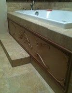 A bathtub is sitting on top of a marble counter in a bathroom.