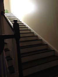 A close up of a set of stairs leading up to the second floor of a house.